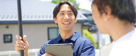 高所カメラで確認しお客様に説明しているスタッフ